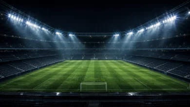 Ilustracyjna grafika piłkarska przedstawiająca pustą murawę oświetloną stadionowymi reflektorami w neutralnej scenie.