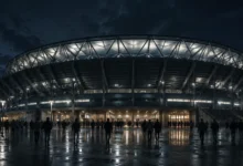 Ilustracyjna grafika piłkarska przedstawiająca zewnętrzny widok stadionu nocą, bez oficjalnych znaków, reklam i logotypów.
