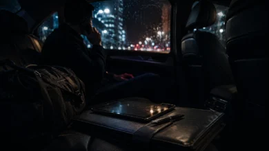 Ilustracyjna grafika piłkarska przedstawiająca agent lub działacz prowadzi nocną rozmowę telefoniczną w samochodzie, bez twarzy i znaków.